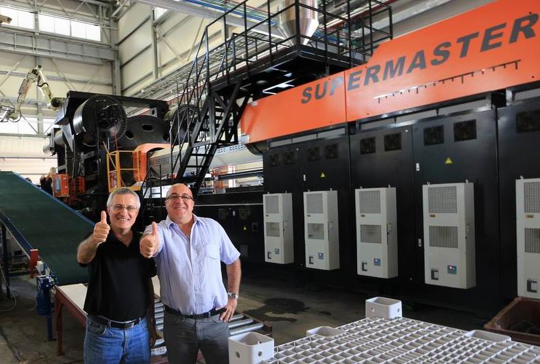 ITZAHK MINTZ (PROJECT DIRECTOR) AND NISIM EMESH (CEO) STANDING IN FRONT OF THE NEW 6500 TON, TWO-PLATEN INJECTION MOLDING MACHINE.