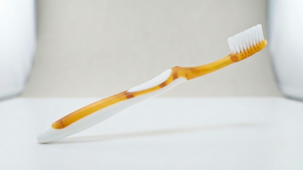 Escova dental bicolor com cabo rígido em PP e pega em TPE macio produzida por injeção bicolor